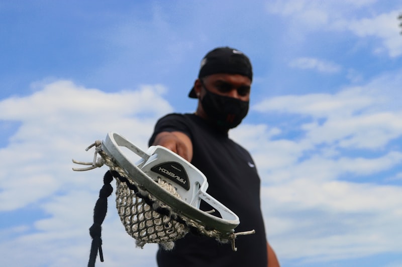 A lacrosse head held up against the sky
